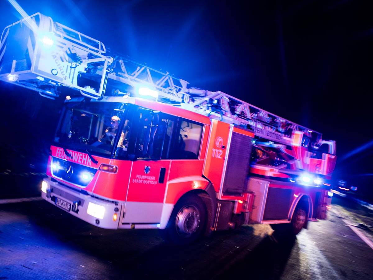 Ein Drehleiterwagen der Feuerwehr fährt mit Blaulicht.