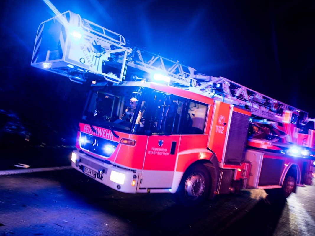 Ein Drehleiterwagen der Feuerwehr fährt mit Blaulicht.