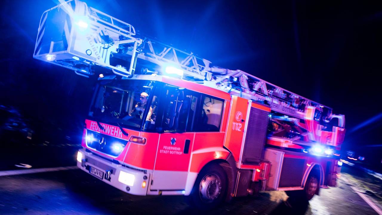 Ein Drehleiterwagen der Feuerwehr fährt mit Blaulicht.