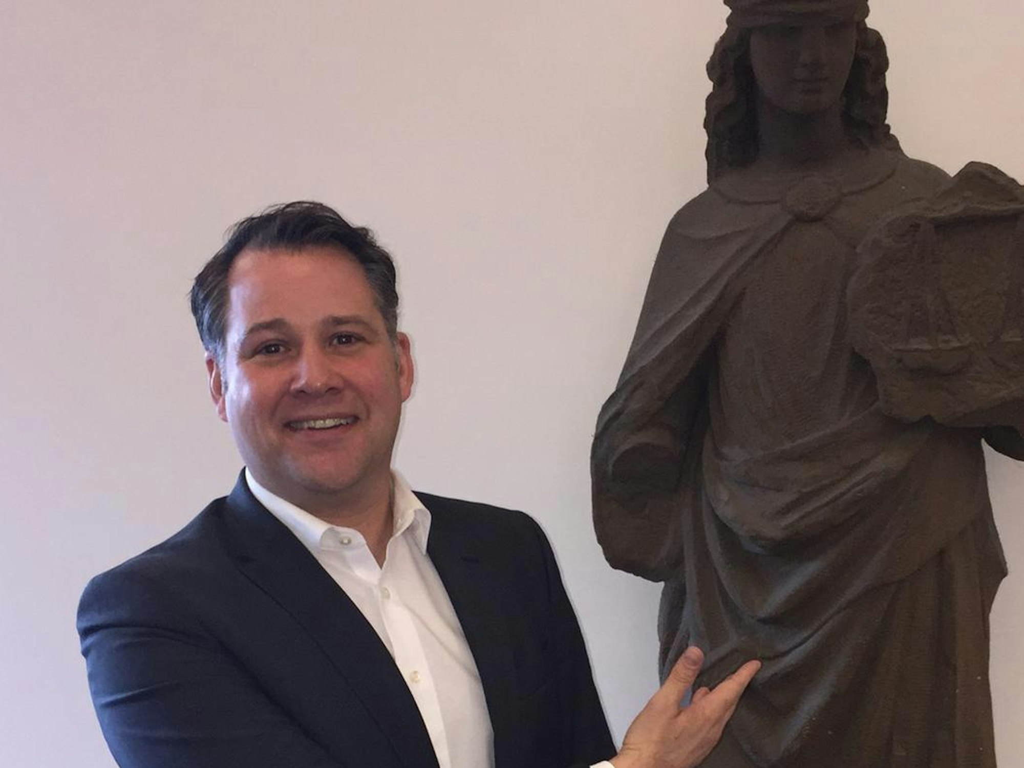 Jan F. Orth im Landgericht neben einer Statue der Justitia, der Göttin der Gerechtigkeit