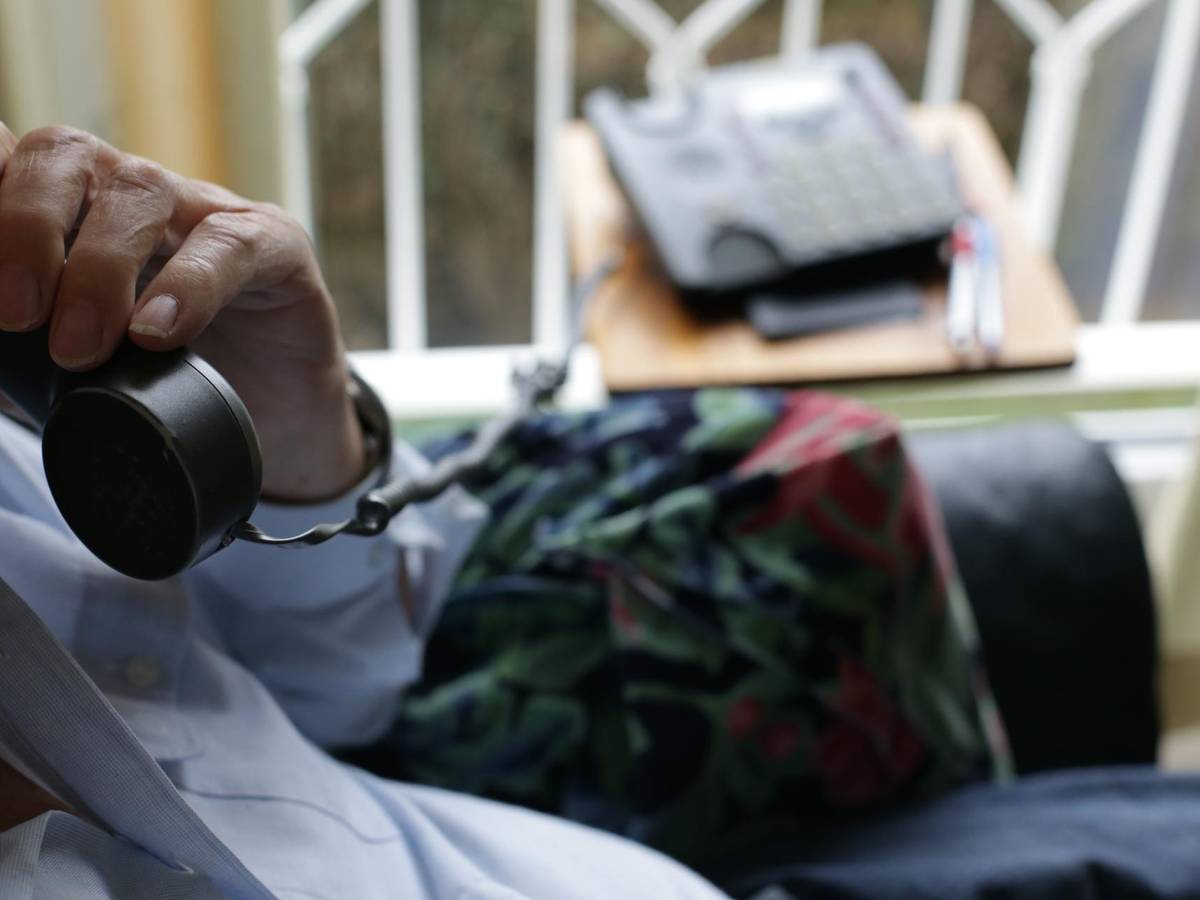 Ein Mann hat einen Telefonhörer in der Hand.