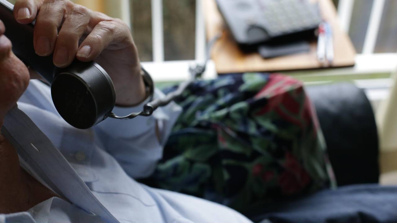 Ein Mann hat einen Telefonhörer in der Hand.