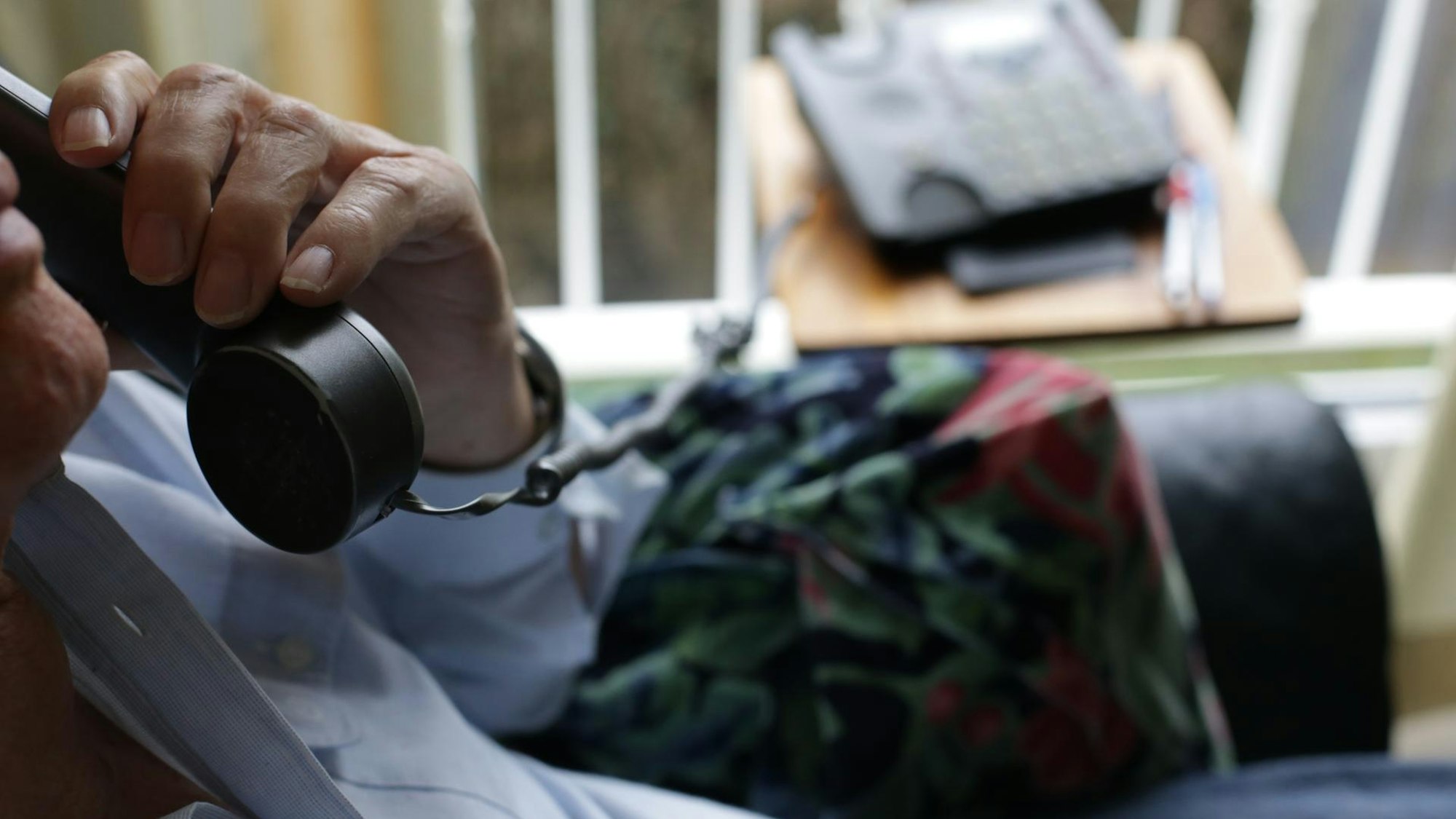 Ein Mann hat einen Telefonhörer in der Hand.