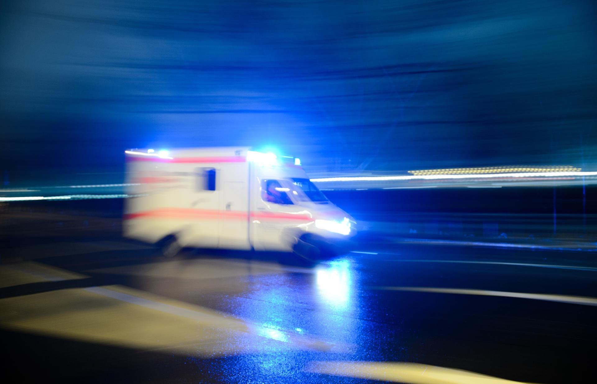 Ein Rettungswagen fährt mit Blaulicht durch eine Straße.