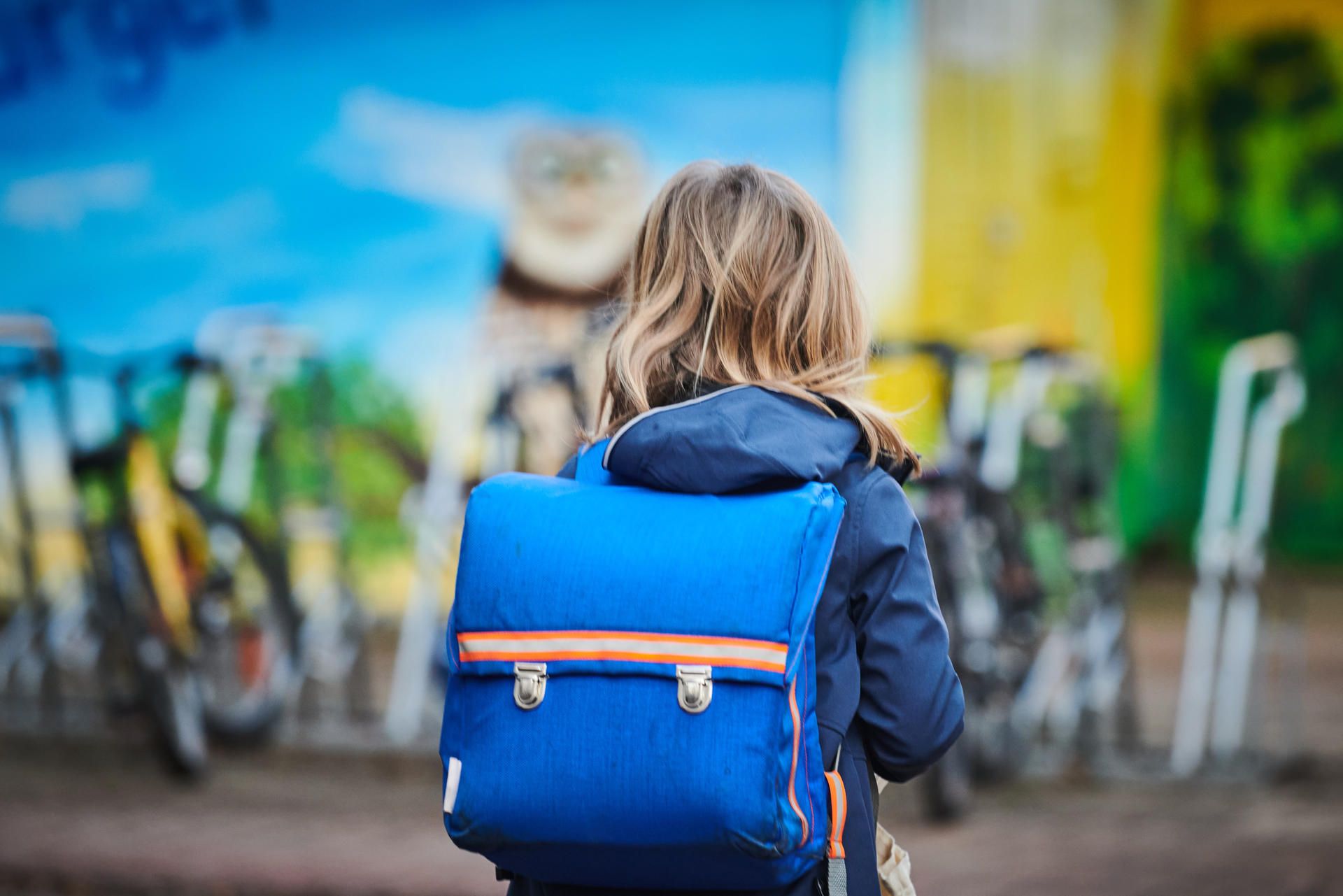 Eine Schülerin trägt einen Schulranzen auf dem Rücken.