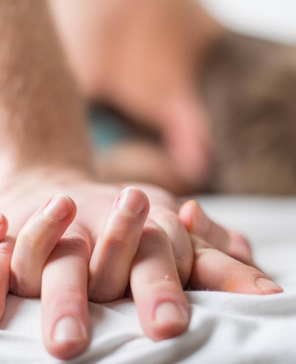Paar knutscht im Bett und hält Händchen