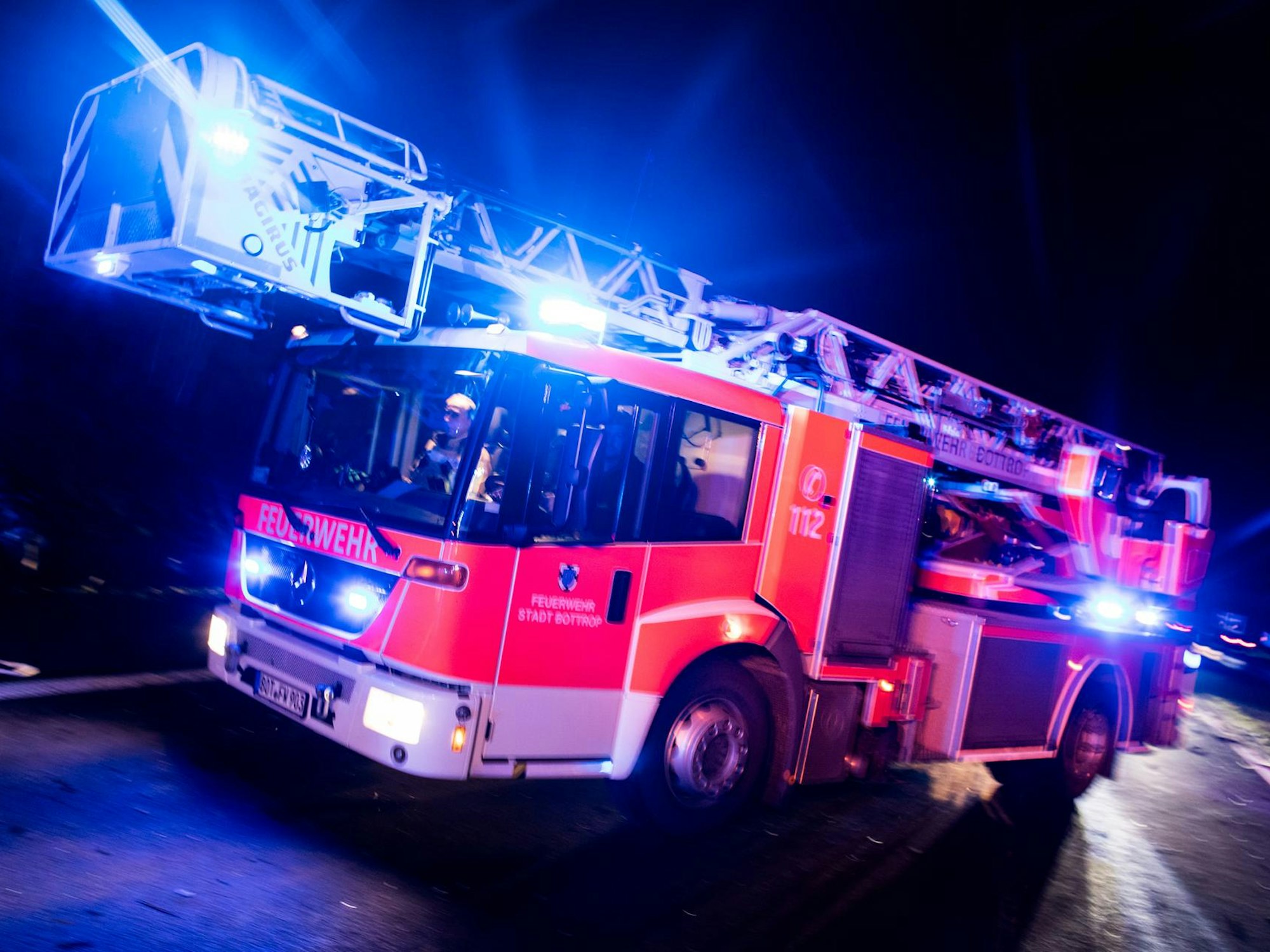 Ein Drehleiterwagen der Feuerwehr fährt mit Blaulicht