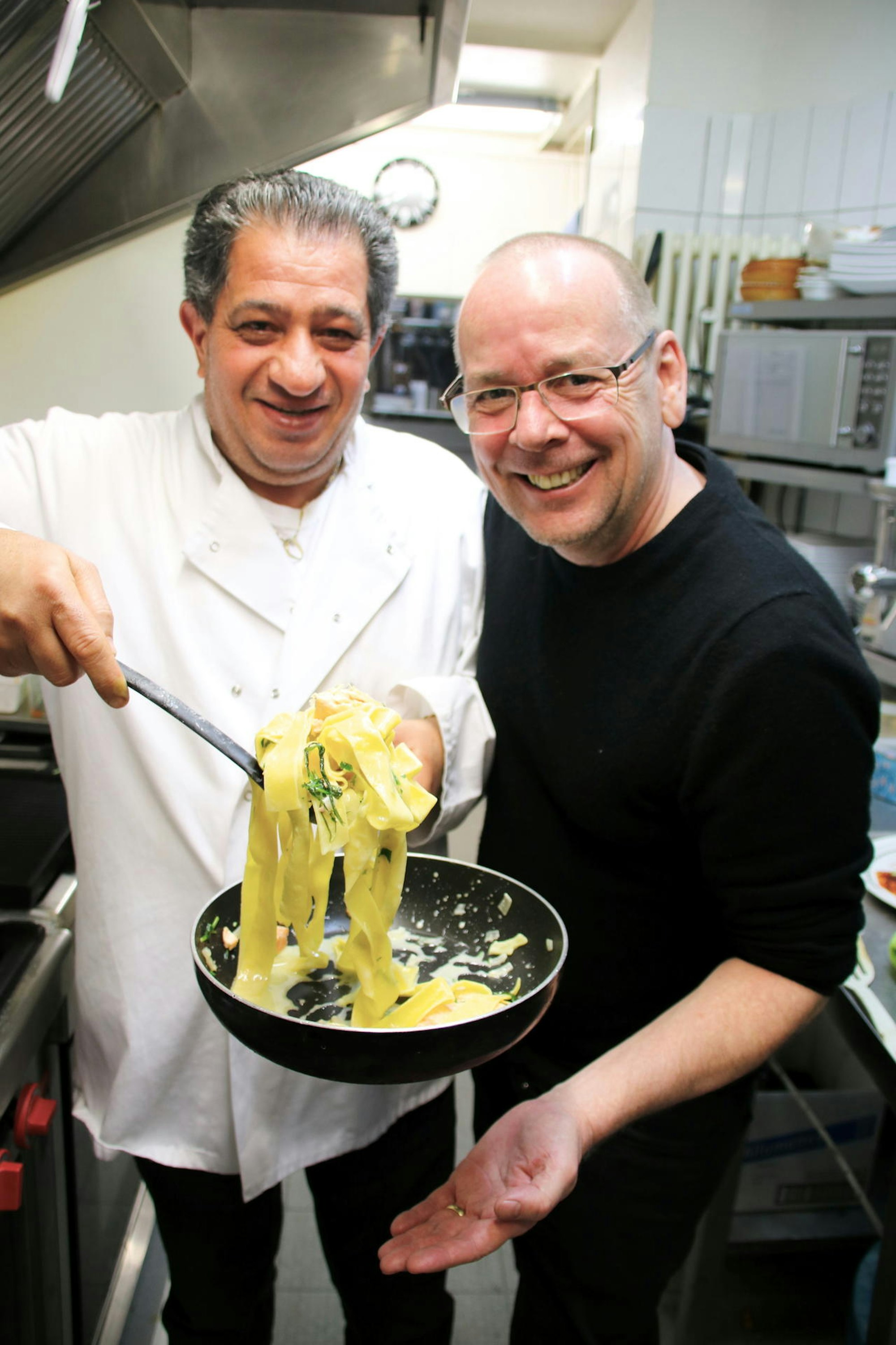 Carmelo Faraci präsentiert Thomas Hackenberg Pasta in einer Pfanne.