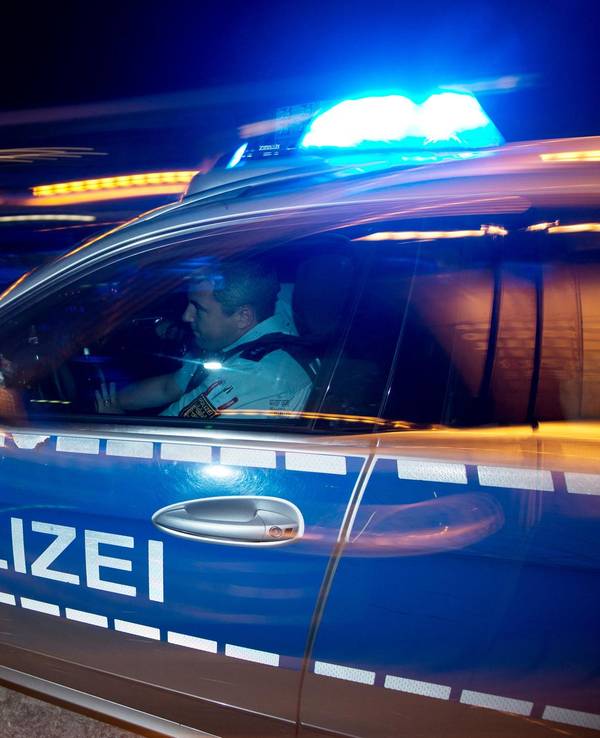 Ein Polizist sitzt in einem Streifenwagen.