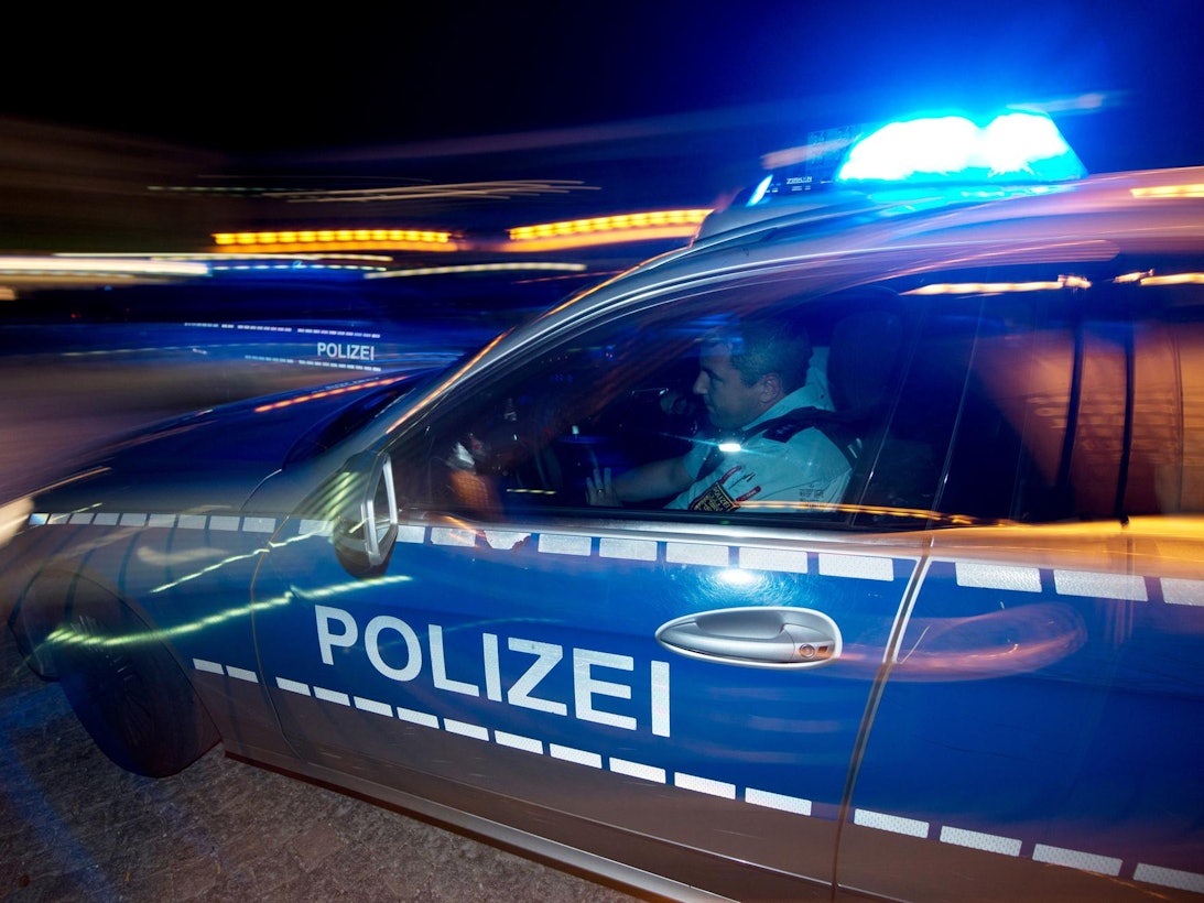 Ein Polizist sitzt in einem Streifenwagen.