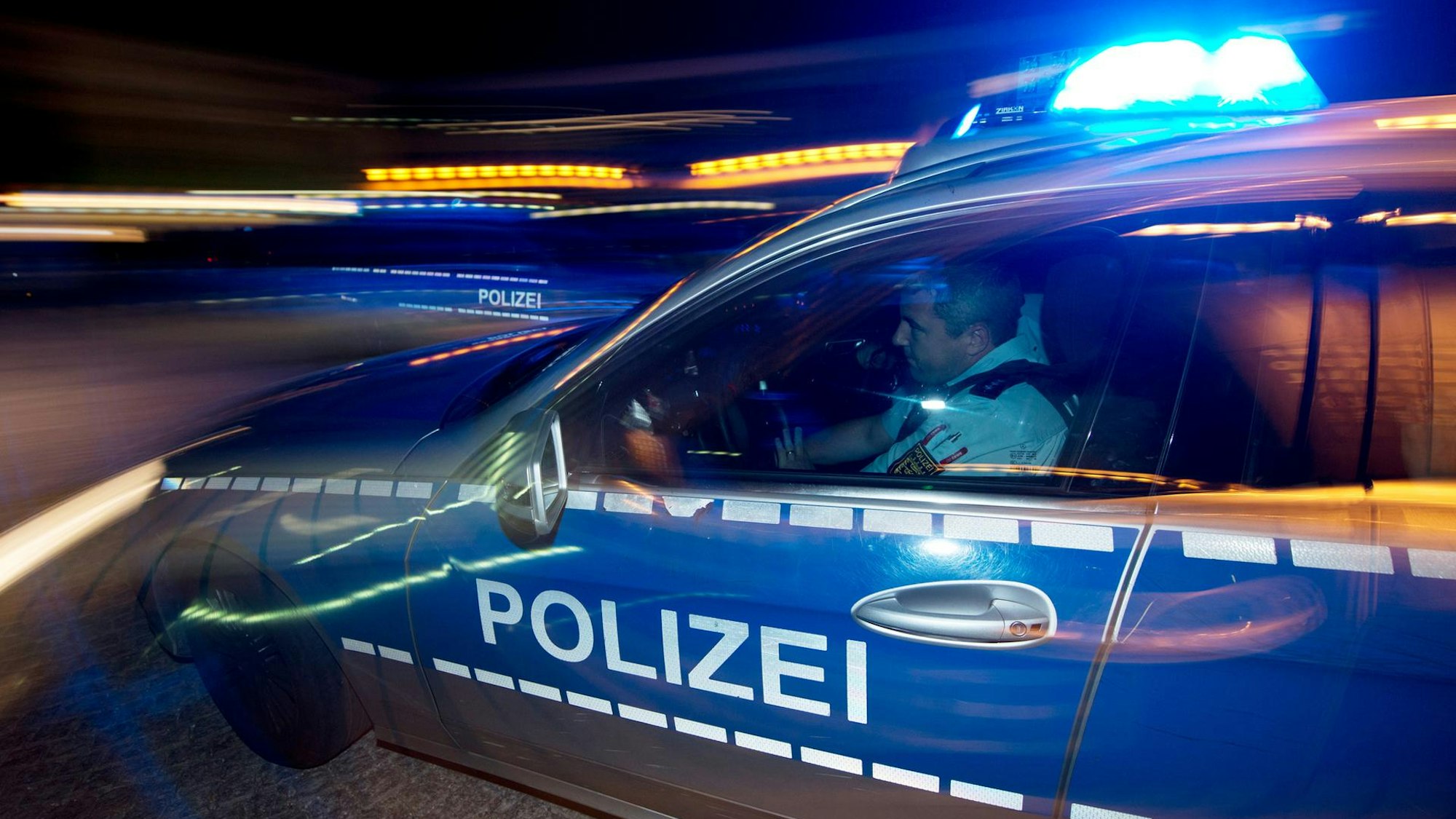 Polizeiwagen rast in der Nacht über die Autobahn.