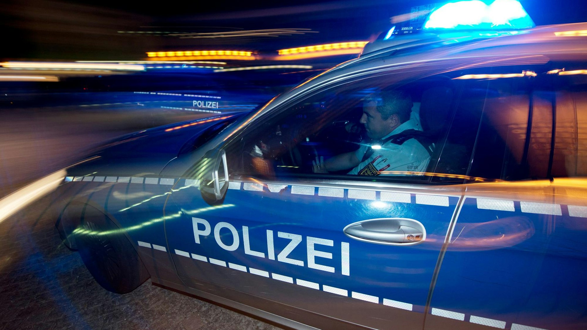 Ein Polizeiauto in der Nacht bei einer Verfolgung (Symbolfoto).