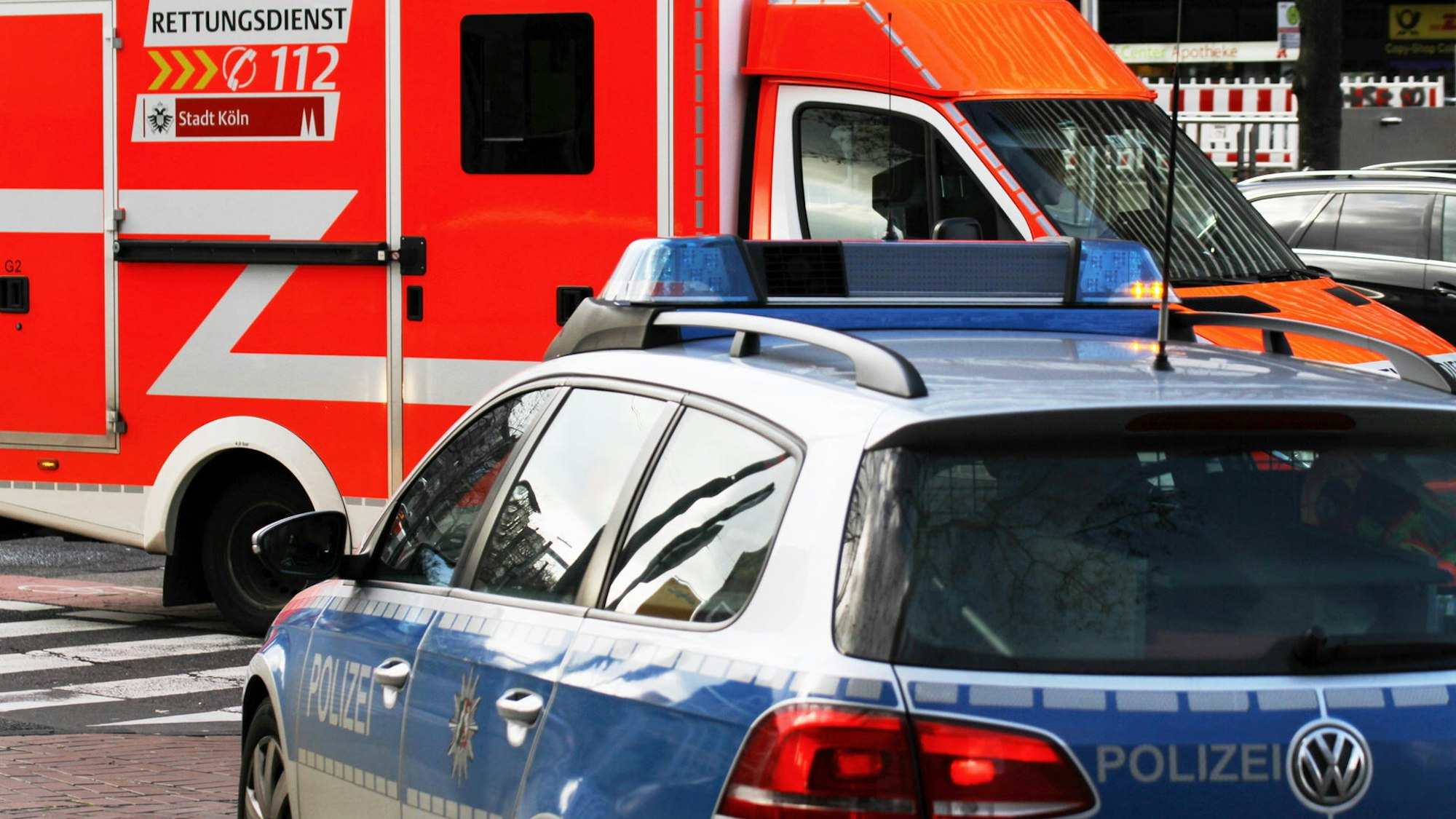 Ein Streifenwagen und ein Rettungswagen stehen auf einer Straße.