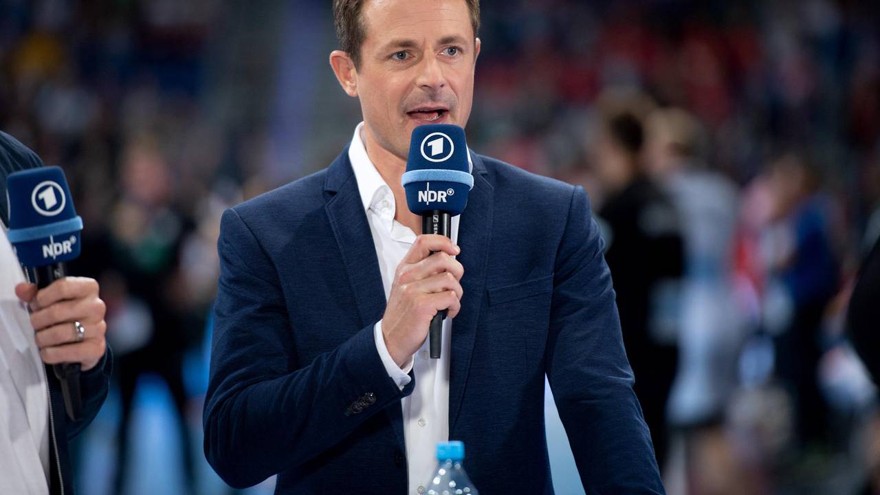 Alexander Bommes moderiert bei einer EM-Übertragung mit einem Mikrofon in der Hand..