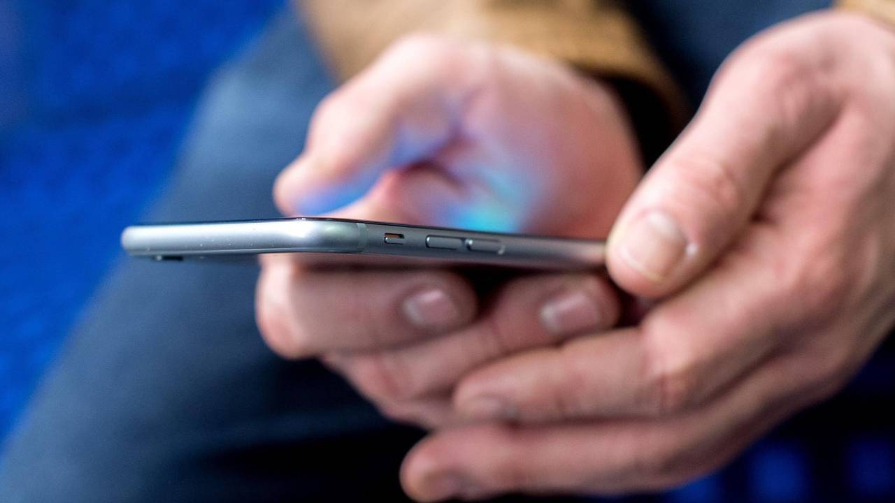 Mann hält ein Smartphone in der Hand.