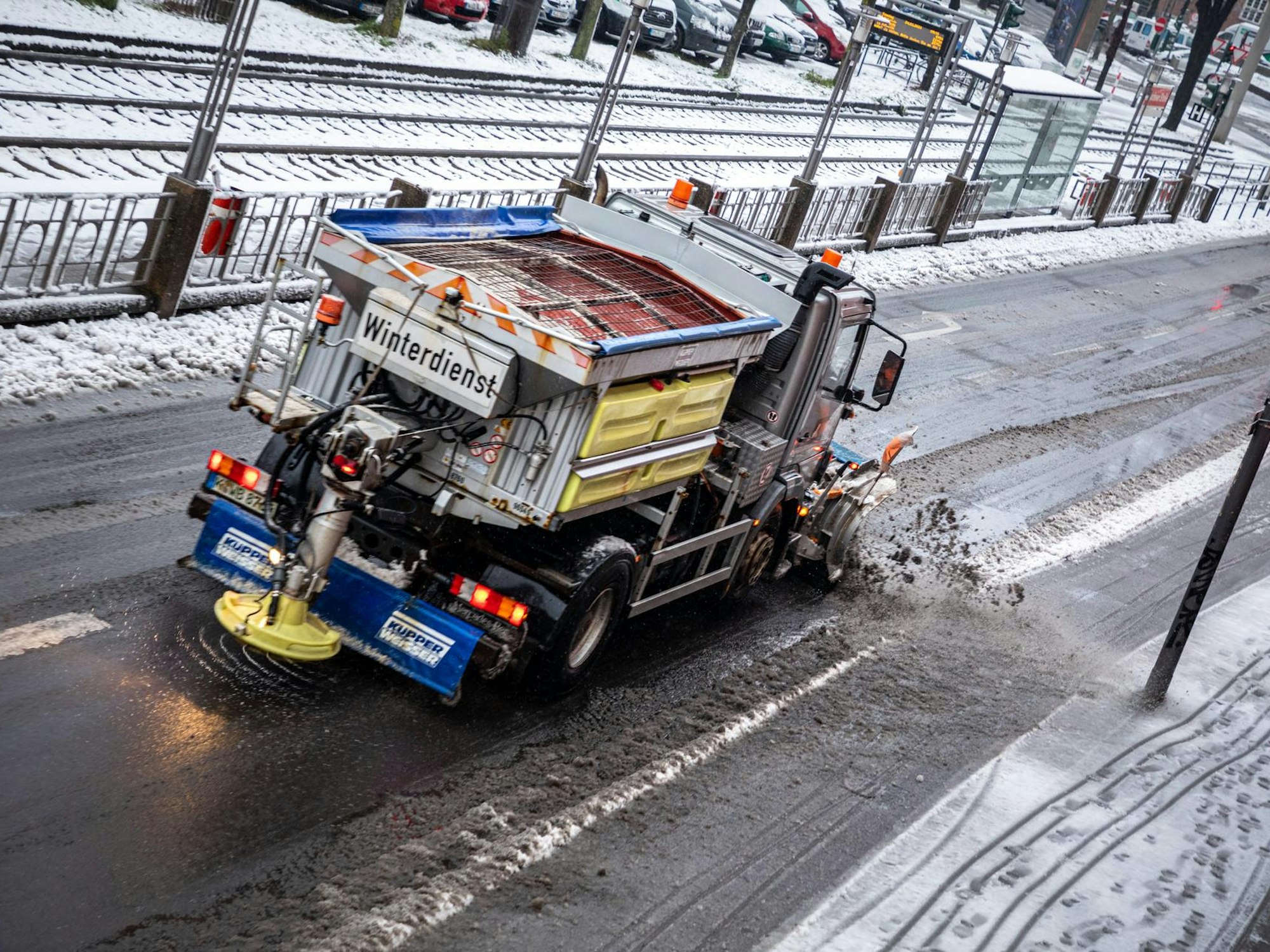 Der Winterdienst der Abfallwirtschaftsbetriebe fährt über eine Straße.