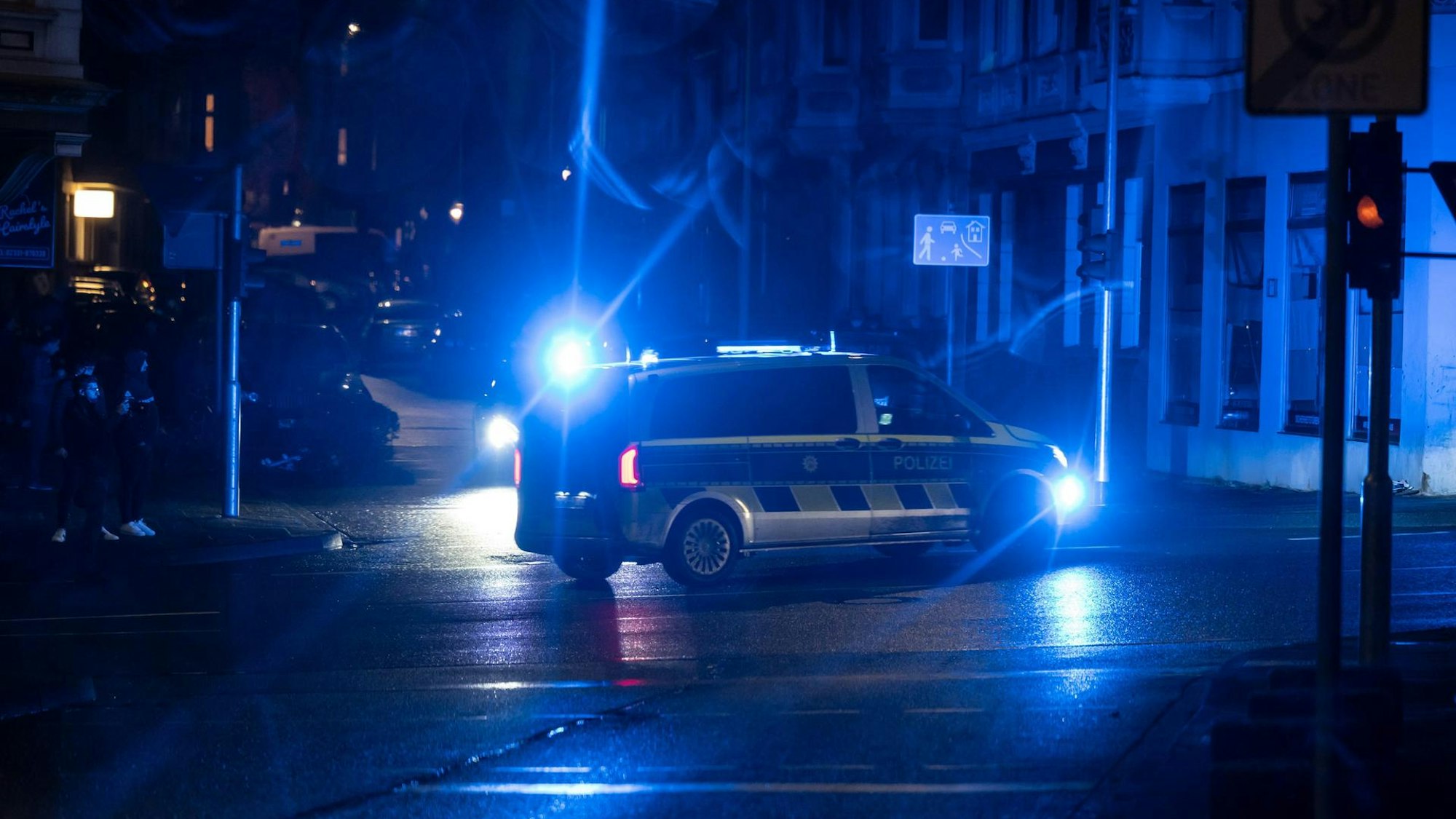 Ein Polizeifahrzeug steht in der Nacht auf einer Straße.