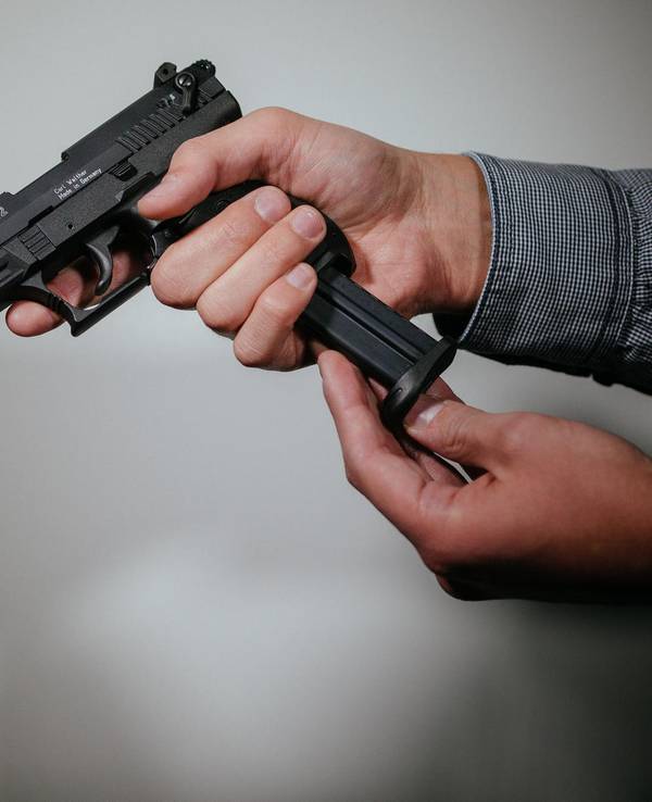 Ein Mann hält eine Waffe in der Hand.