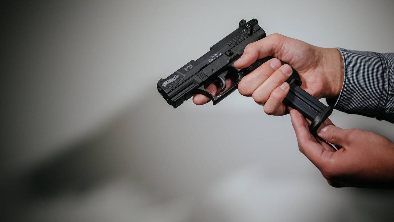Ein Mann hält eine Waffe in der Hand.
