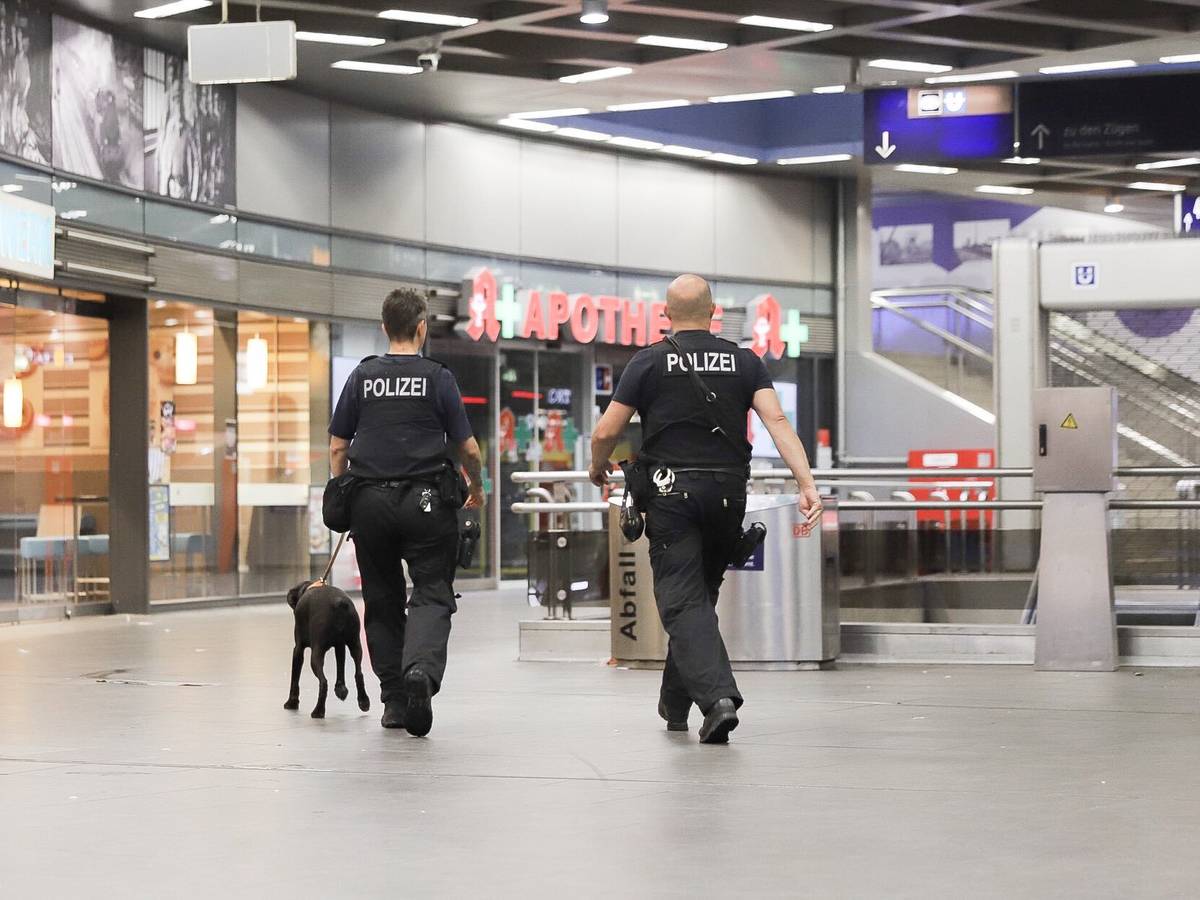 Polizisten laufen mit einem Diensthund durch den Hauptbahnhof Gelsenkirchen.