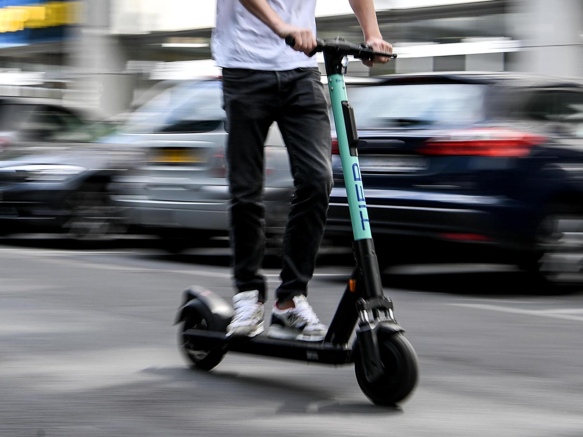 Ein Mann fährt mit einem E-Scooter.