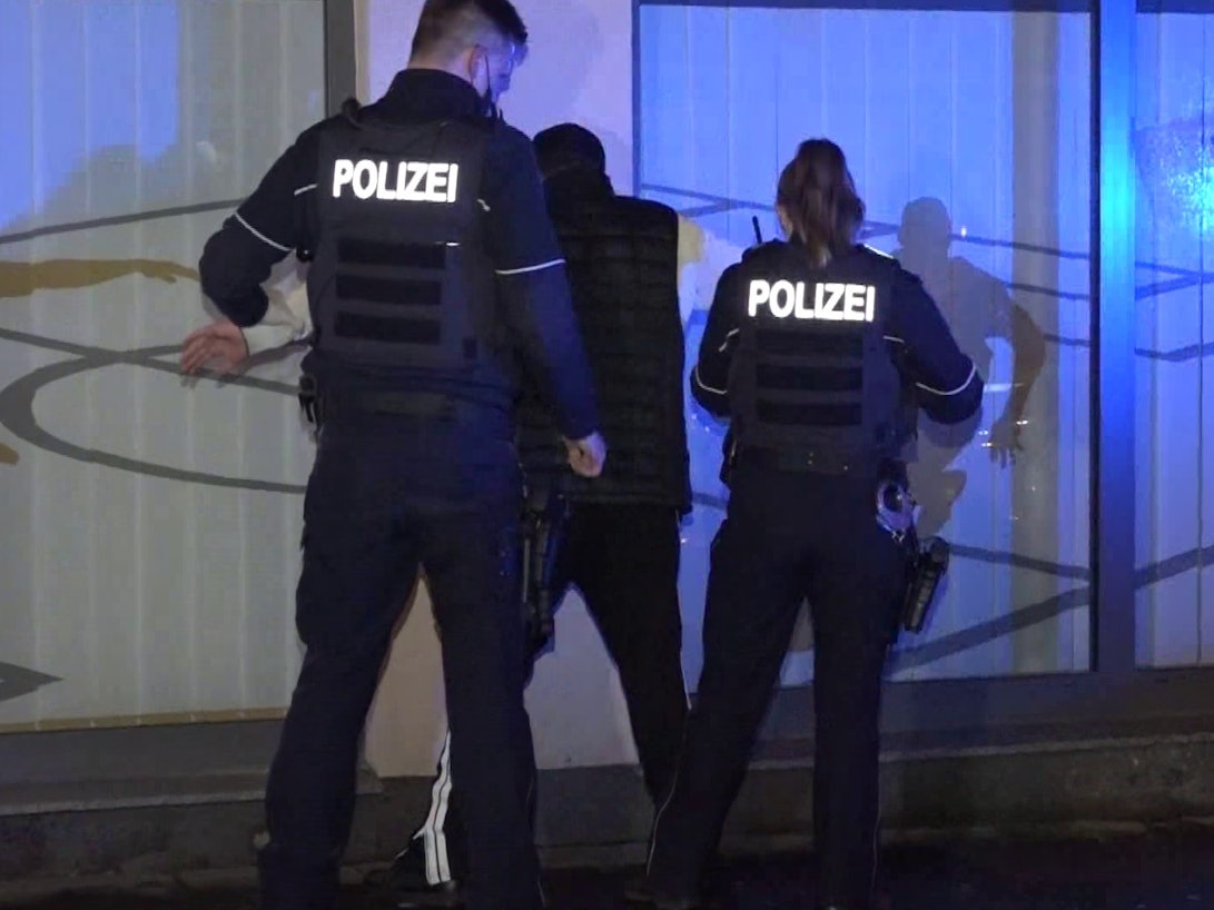 Polizisten nehmen einen Mann fest.