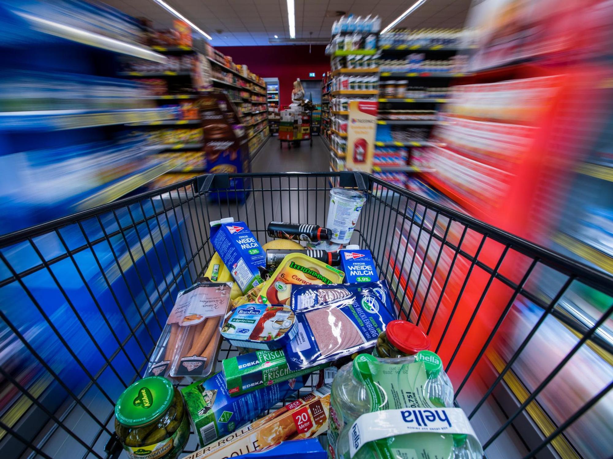Lebensmittel und andere Waren in einem Einkaufswagen.