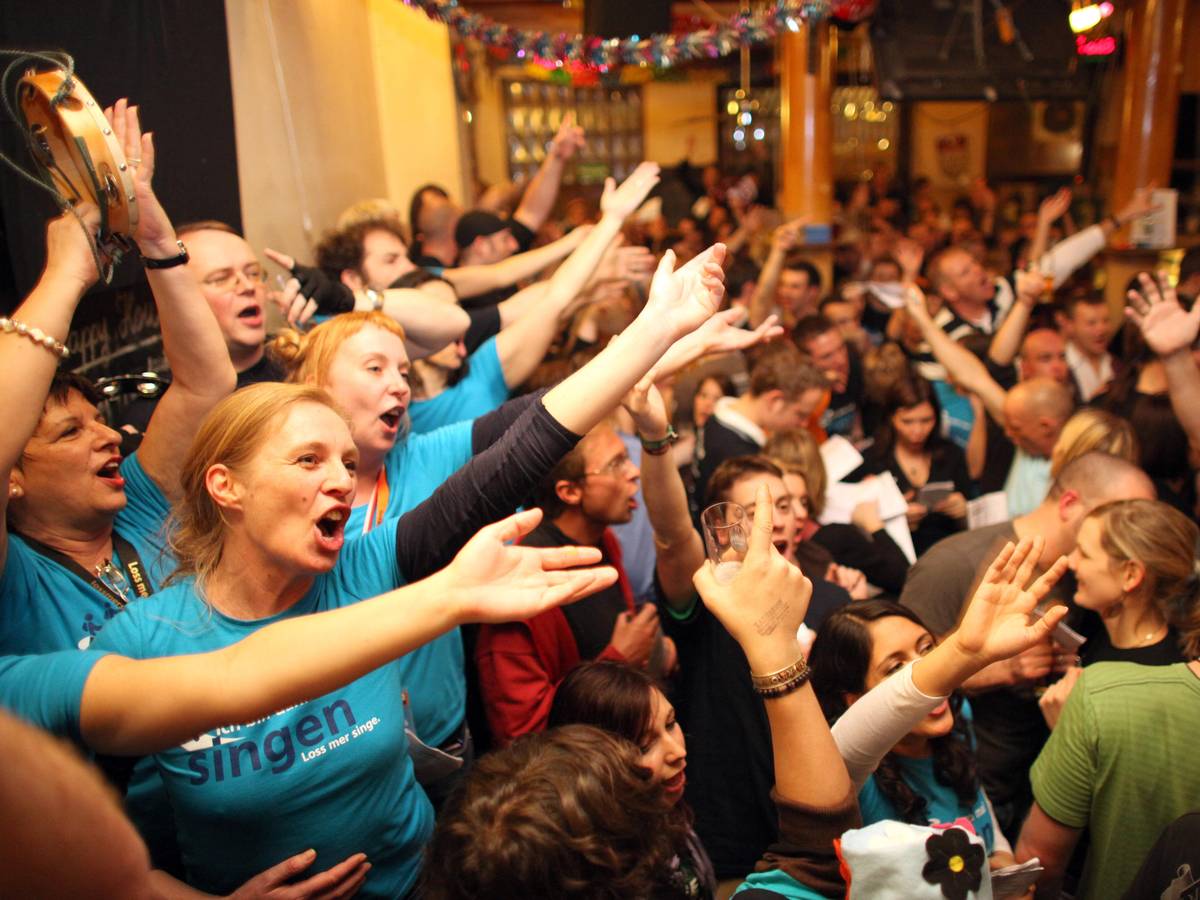 Jecke stehen in der Kneipe und singen.