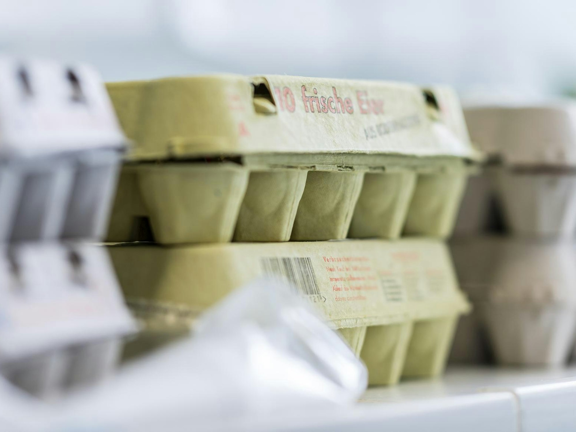 Graue und grüne Eierkartons stehen über- oder nebeneinander.