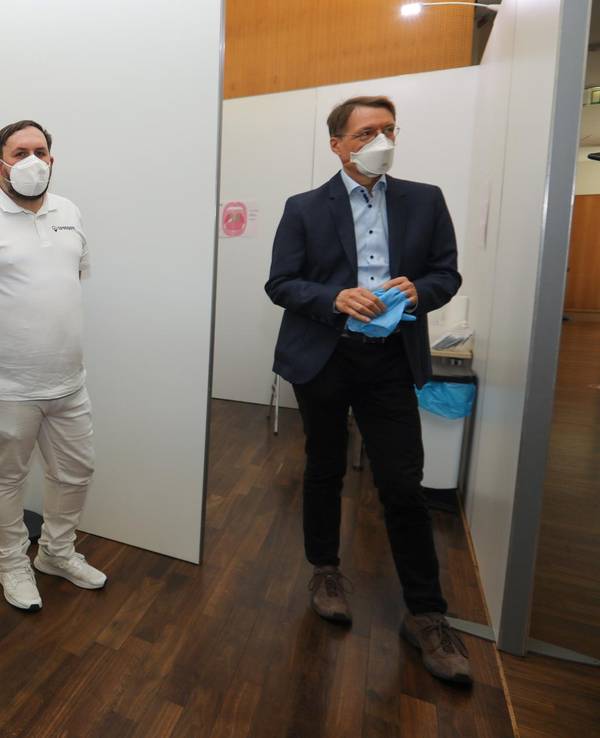 Karl Lauterbach steht im Testzentrum und unterhält sich mit den Betreibern