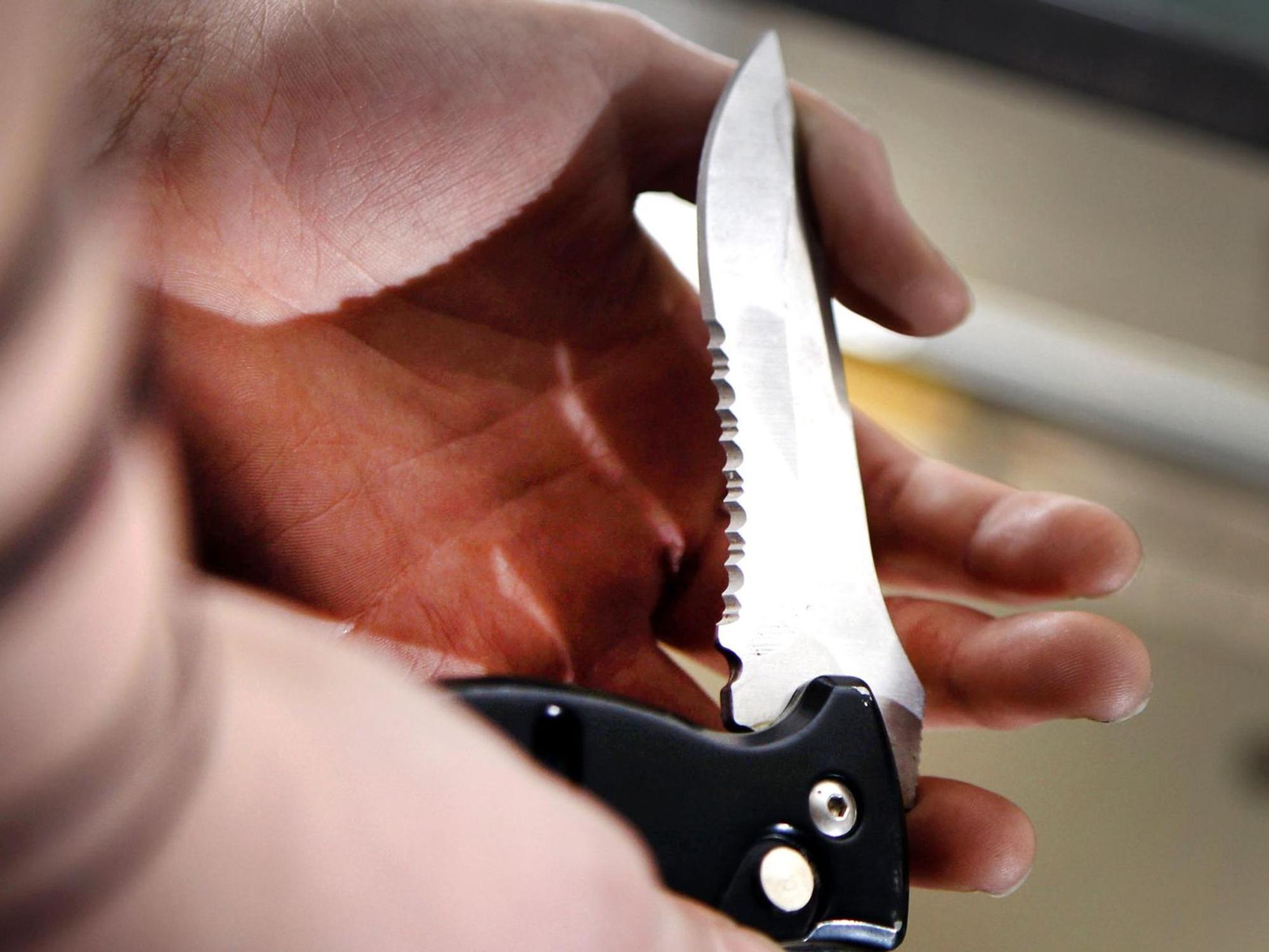 Ein Mann hält ein Messer in der Hand.