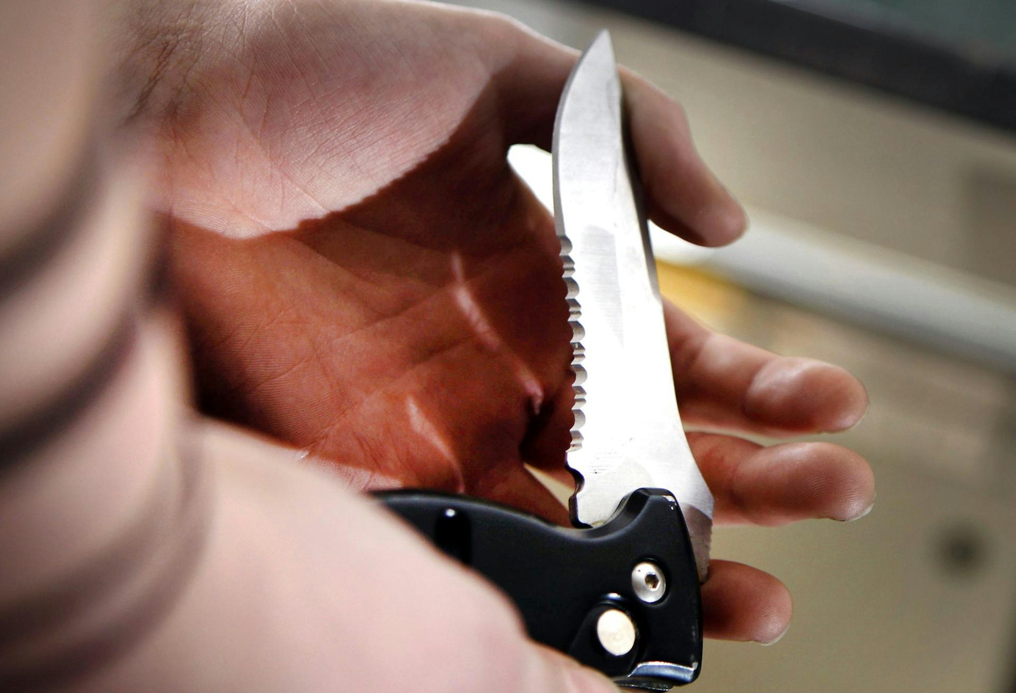 Mann hält ein Messer gezückt.