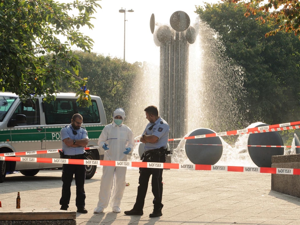 Einsatzkräfte und Spurensicherung stehen am Brunnen am Ebertplatz in Köln.