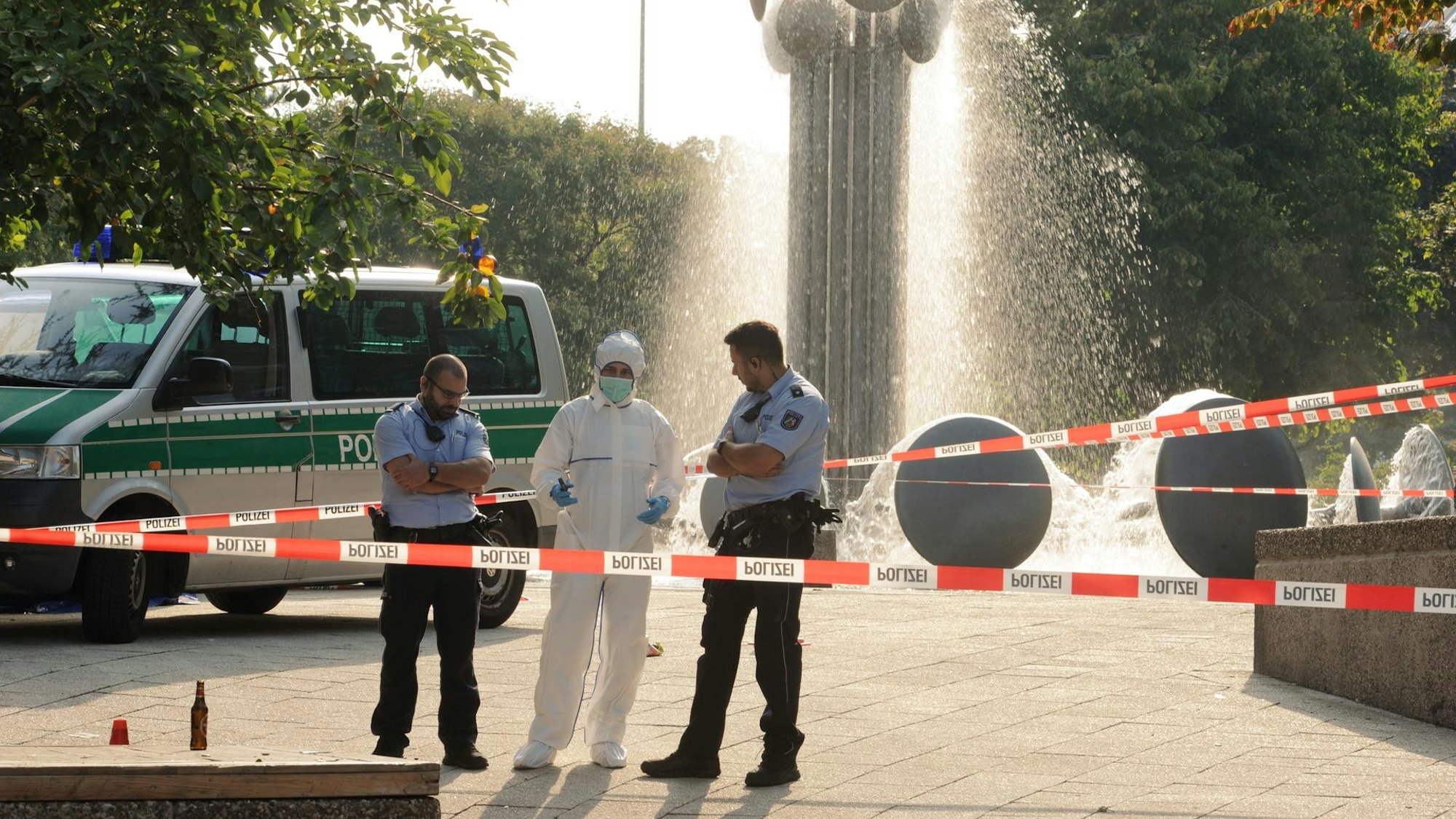 Einsatzkräfte und Spurensicherung stehen am Brunnen am Ebertplatz in Köln.