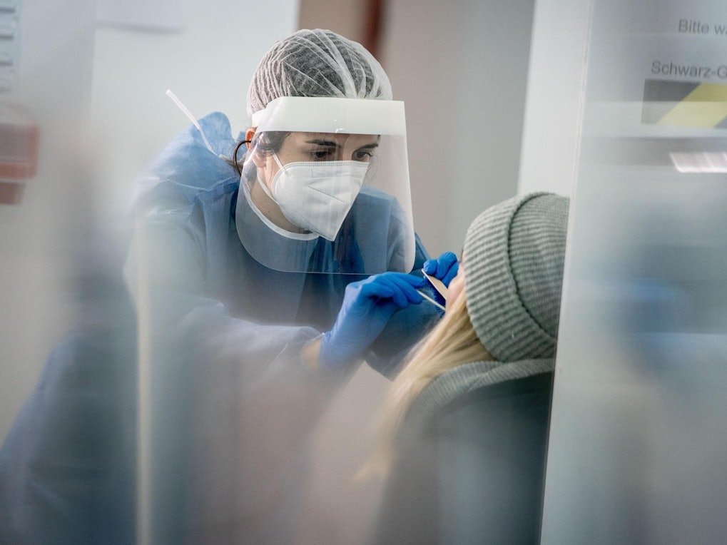 Die gemeldeten Zahlen sind weiter rückläufig. Das Symbolbild zeigt, wie ein Corona-Schnelltest in einer Corona-Teststation durchgeführt wird.