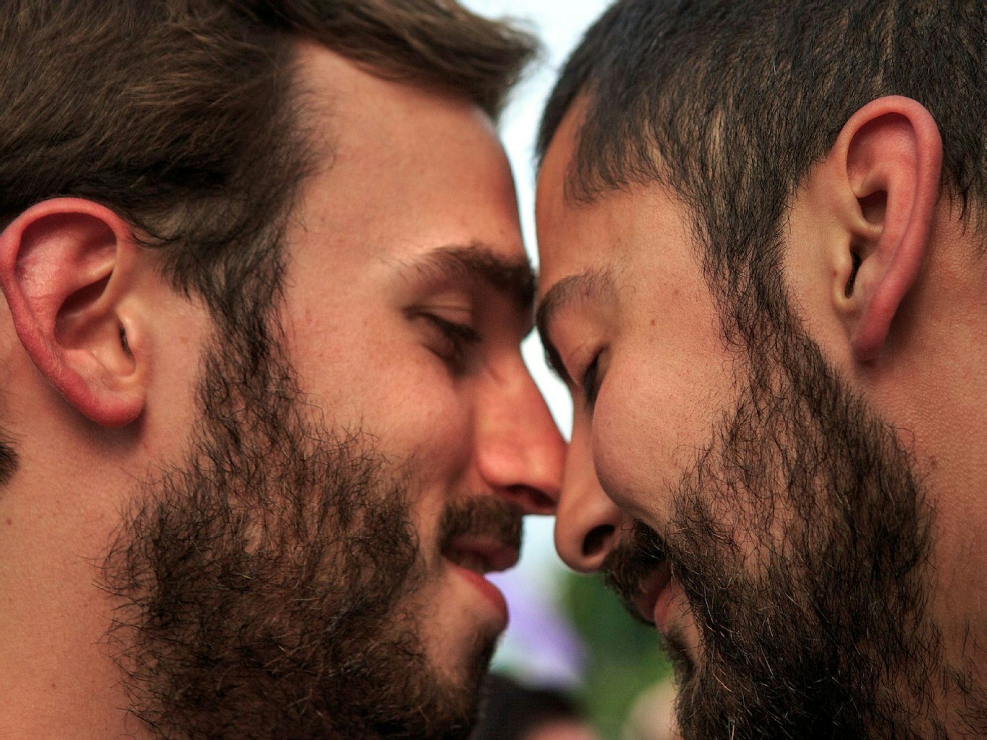 Zwei Männer berühren sich liebevoll mit den Köpfen.