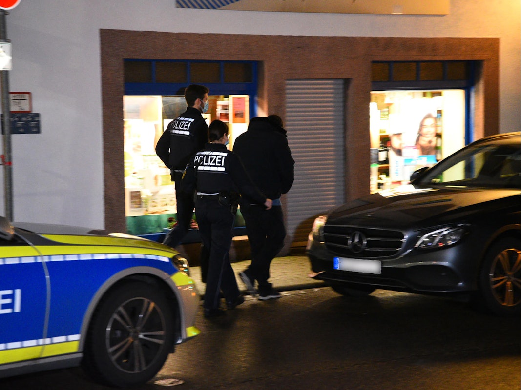 Zwei Polizisten kontrollieren einen jungen Mann.
