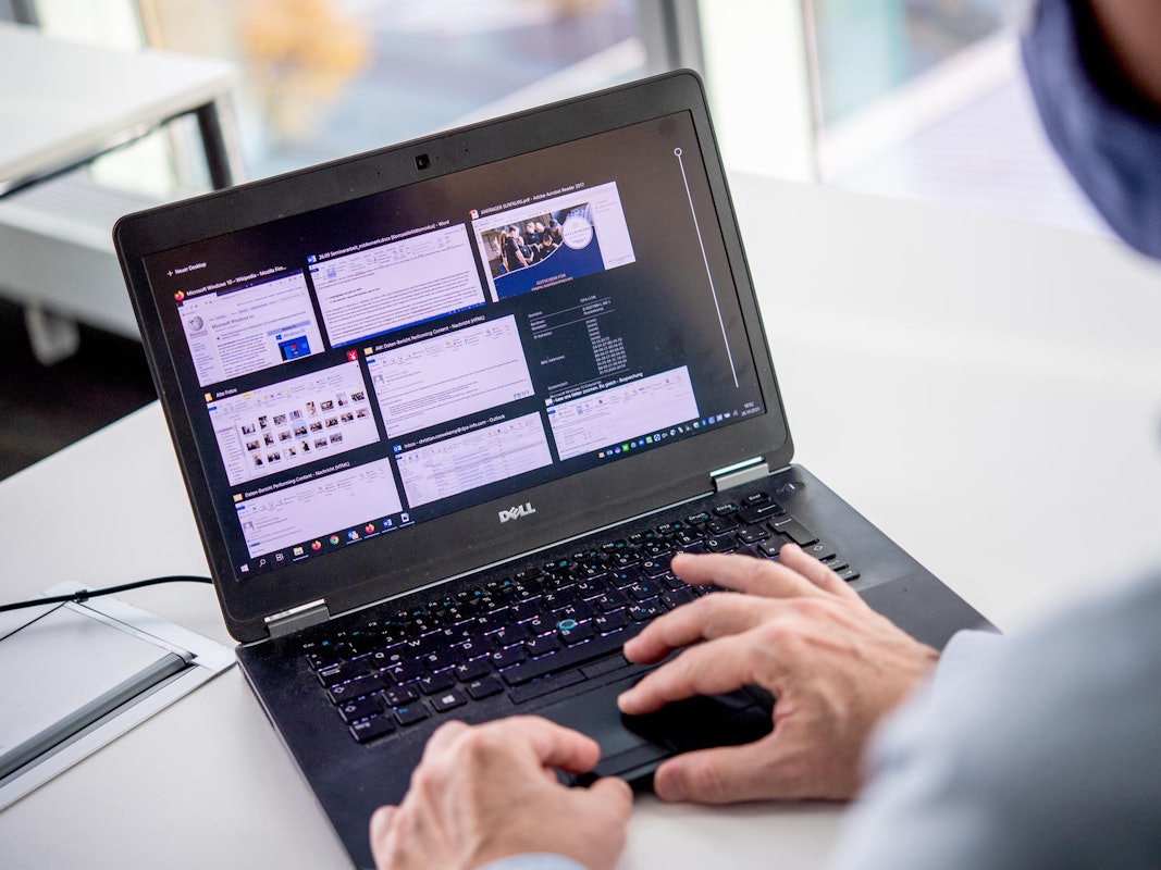 Ein Mann sitzt vor seinem Laptop.