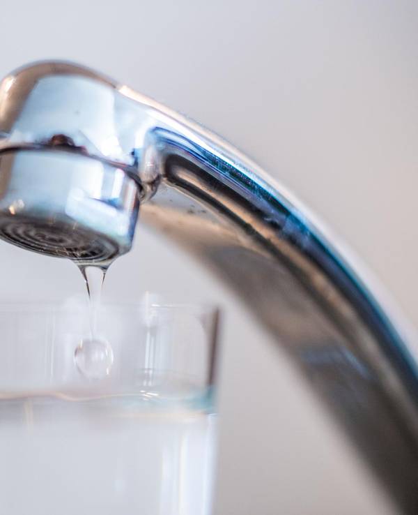 Das Symbolfoto von 2018 zeigt einen Wasserhahn, unter dem ein fast volles Wasserglas steht.