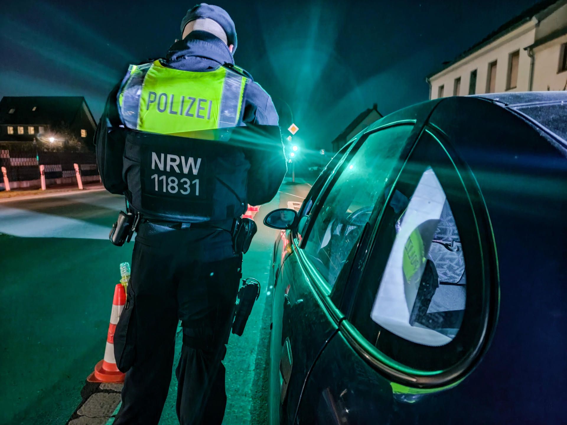 Ein Polizist steht neben einem Auto.