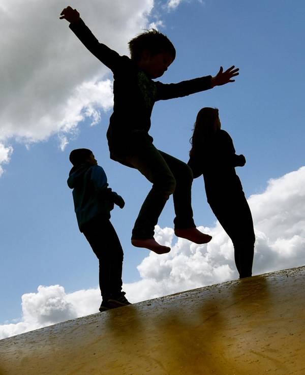 Kinder springen draußen auf einer Hüpfburg