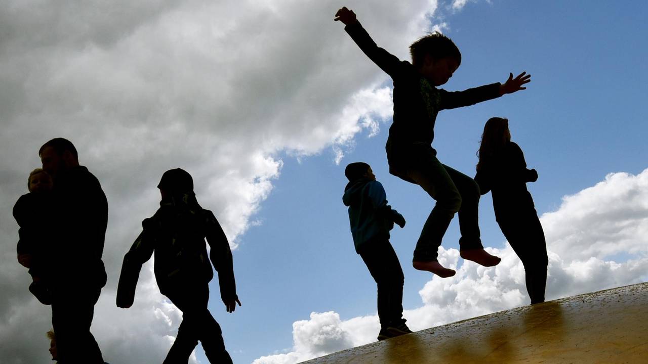 Kinder springen draußen auf einer Hüpfburg