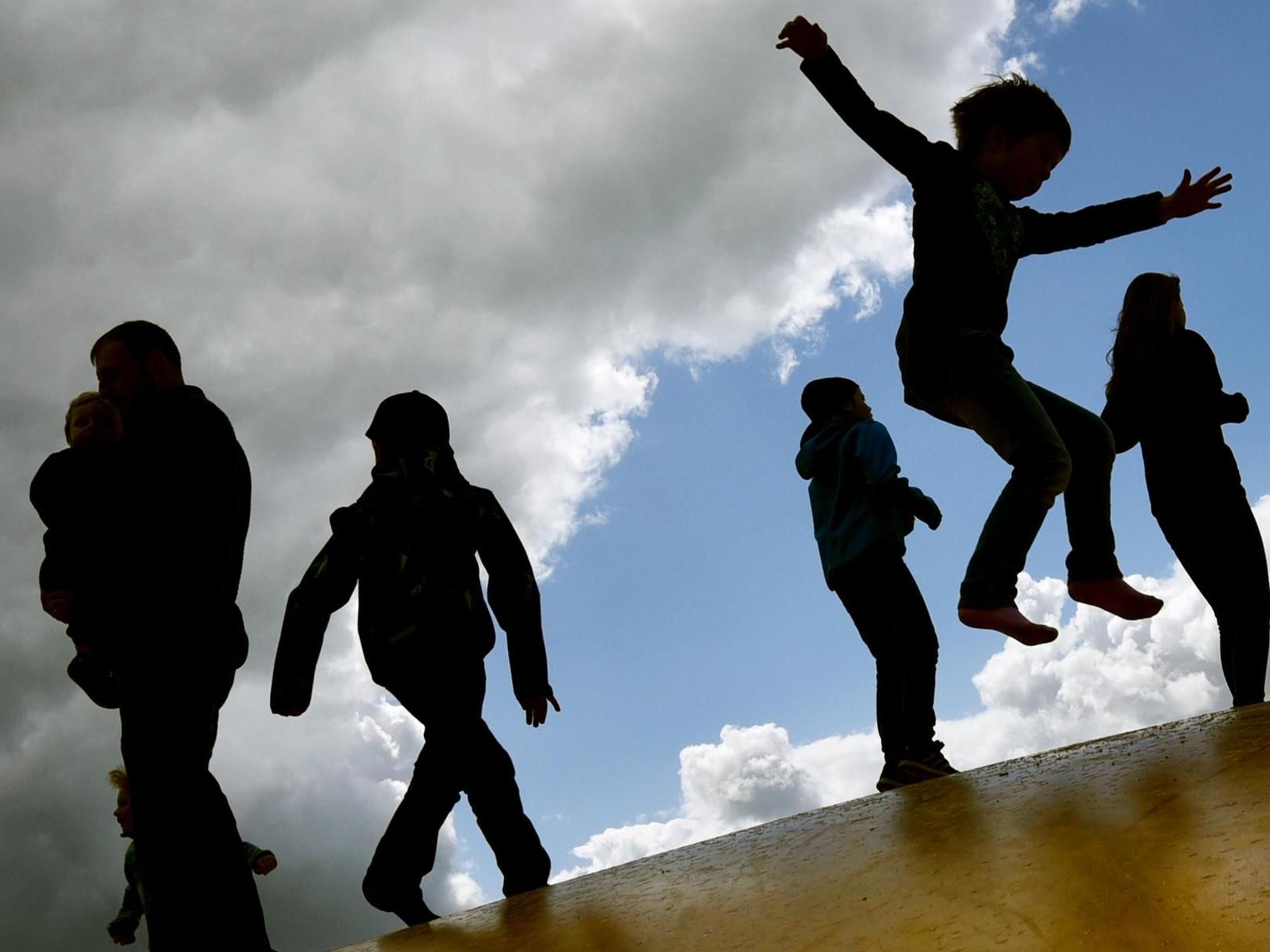 Kinder springen draußen auf einer Hüpfburg