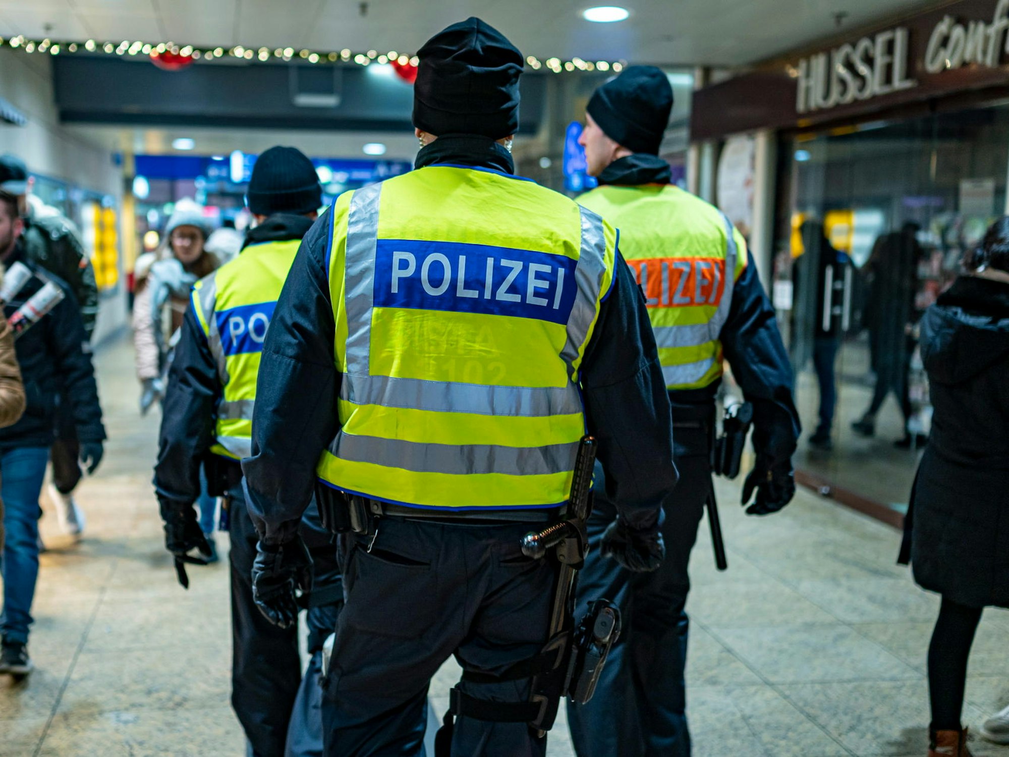 Drei Bundespolizisten laufen durch den Kölner Hauptbahnhof.