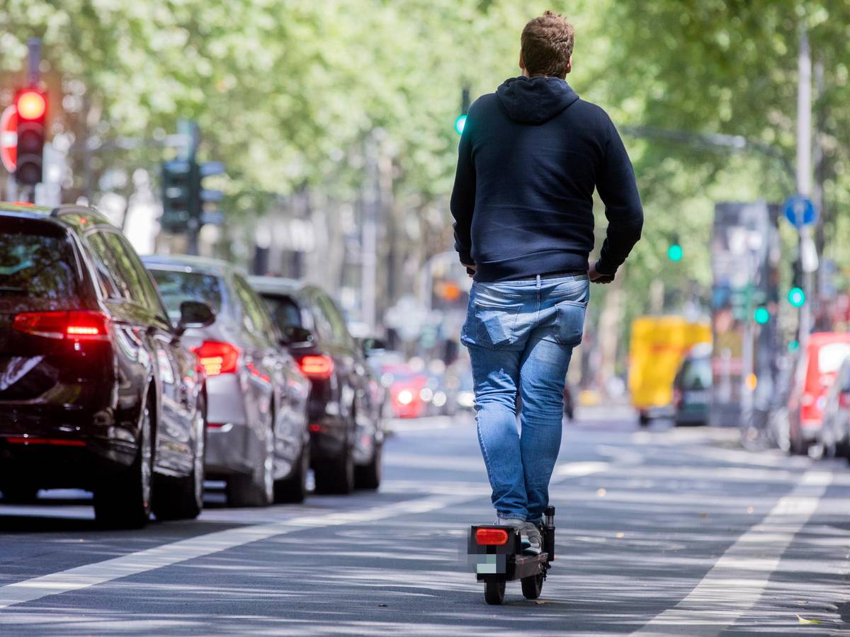 Ein Mann fährt in Köln auf einem E-Scooter.