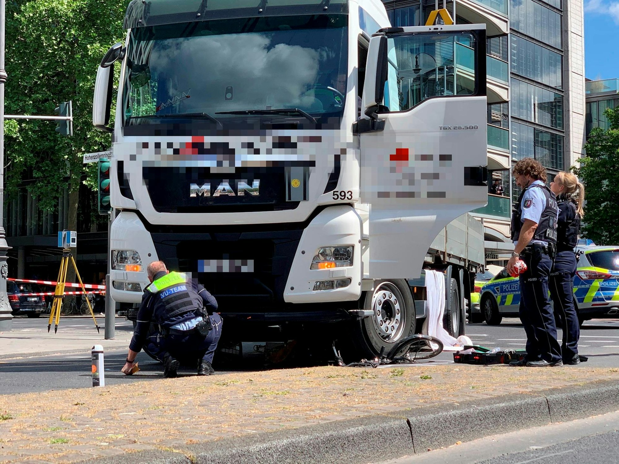 Ein weißer Lkw steht auf der Fahrbahn, unter einem Rad liegt ein zerquetschtes Fahrrad.