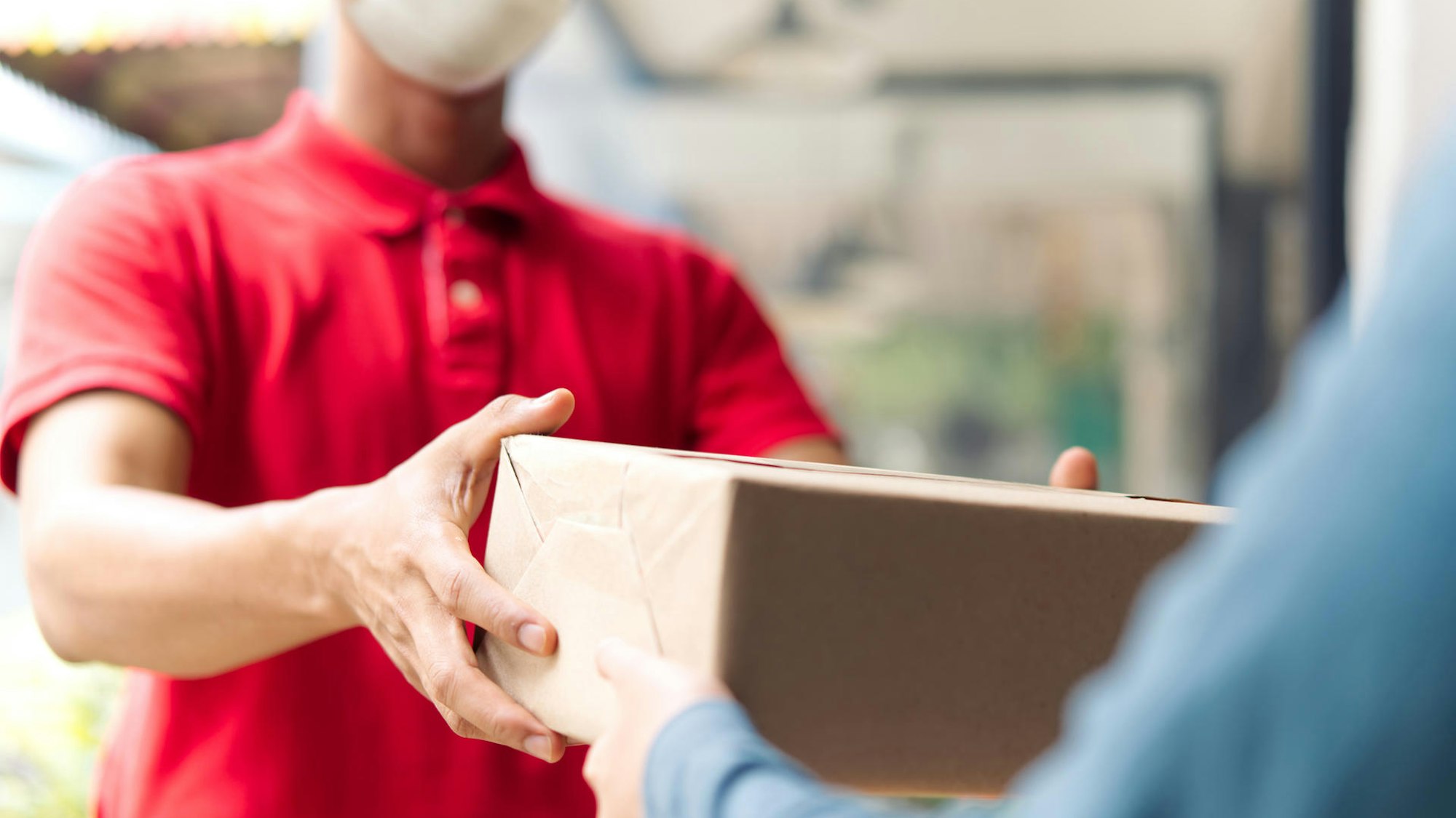 Ein Mann übergibt ein Päckchen.