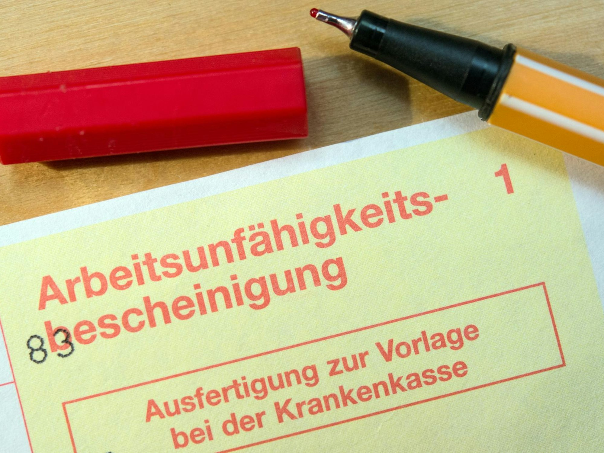 Ein gelber Schein liegt auf einem Tisch.